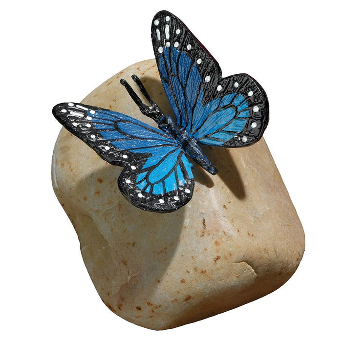 PAPILIO ULYSSES BUTTERFLY ON ROCK STATUE